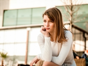 vrouw ondersteund hoofd en kijkt doelloos voor zich uit